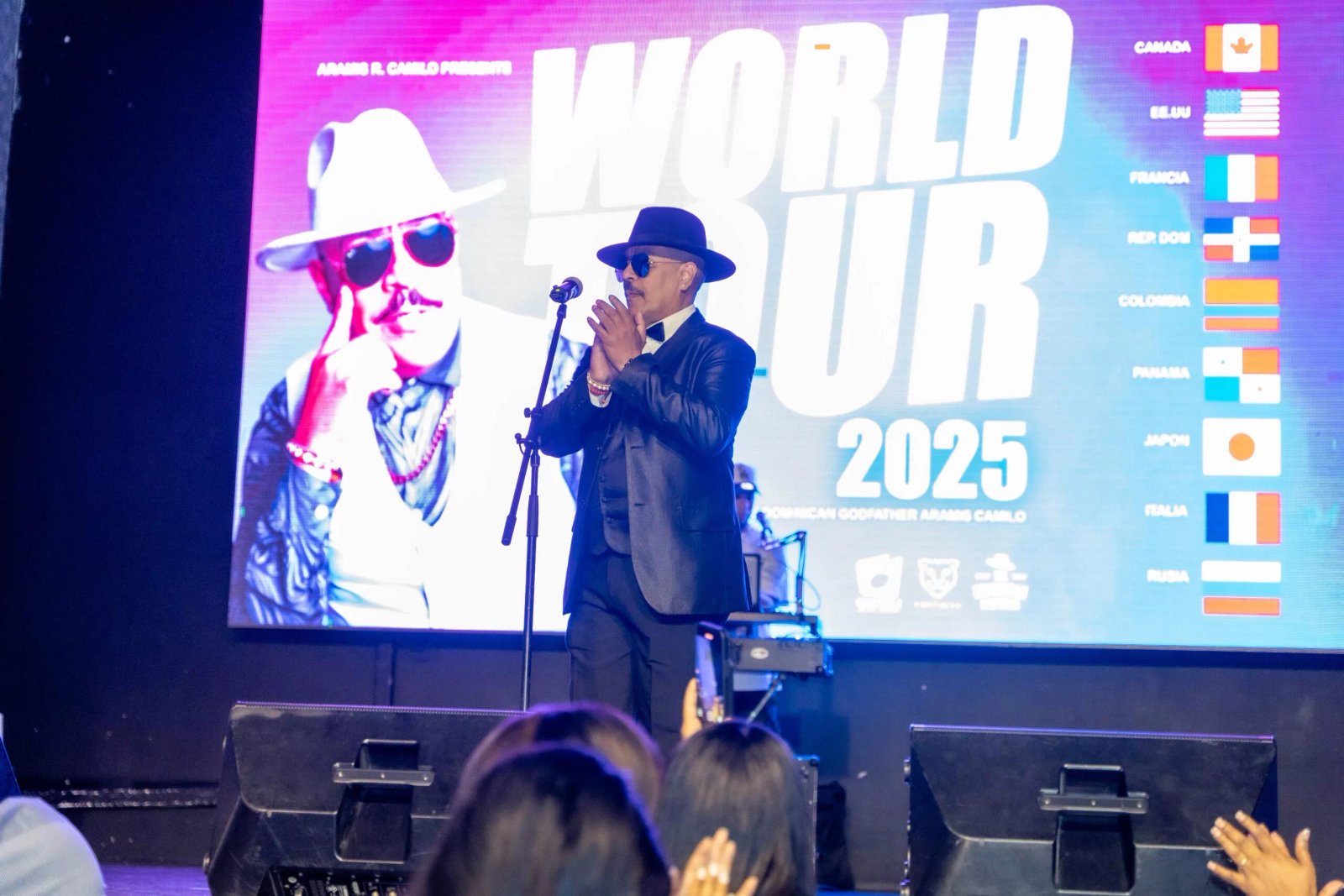 Hombre aplaudiendo en evento de gira mundial 2025.