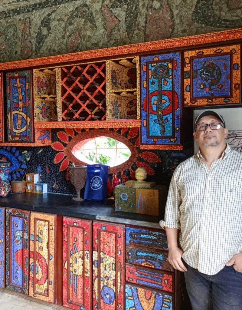 Cocina con mosaicos coloridos y persona de pie.