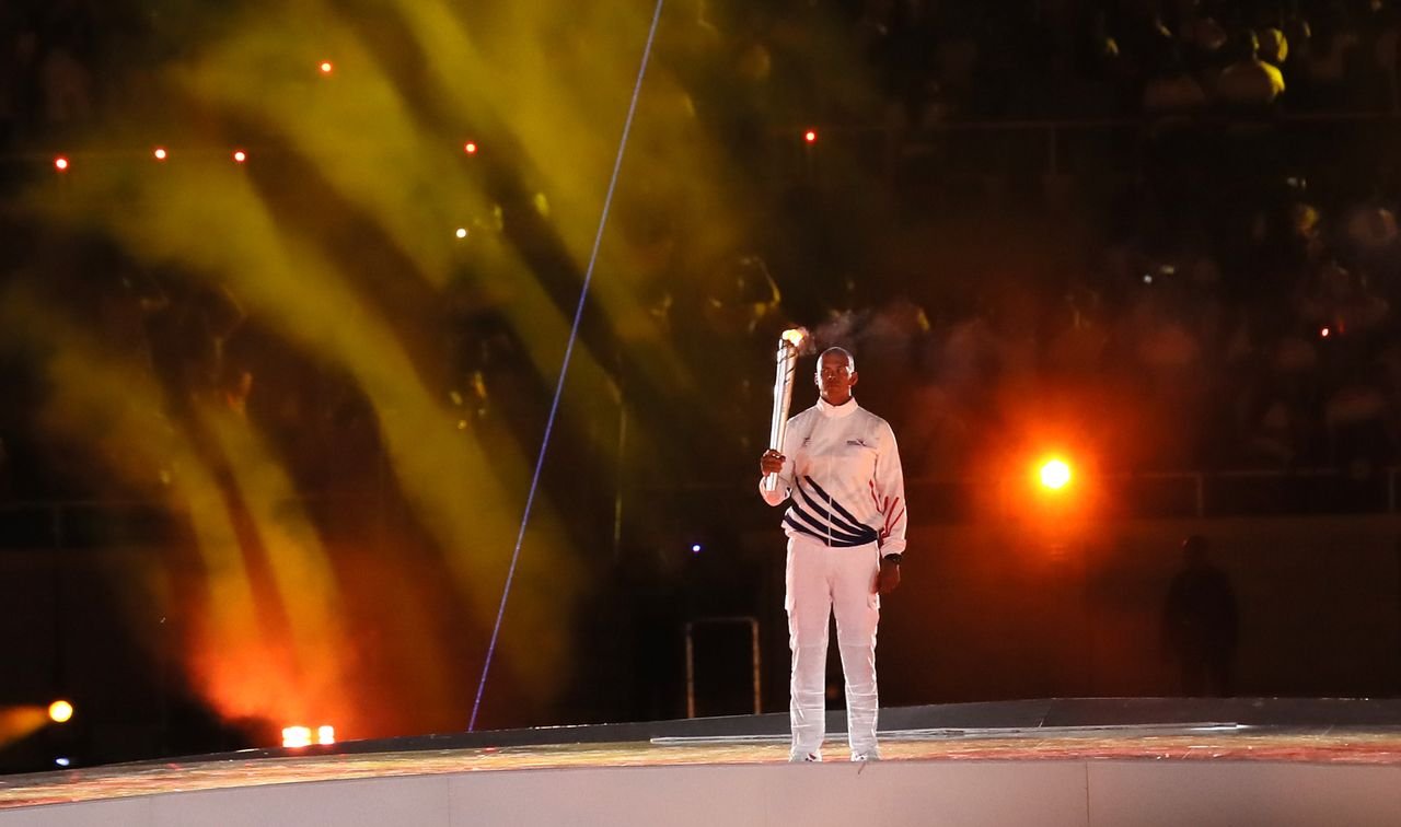 El doble medallista olímpico Félix Sánchez lleva la antorcha para dejar encendido el pebetero, en la ceremonia inaugural de los XXV Juegos Centroamericanos y del Caribe.
